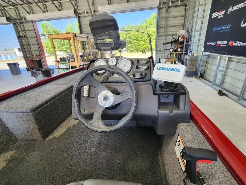 Slide: The Image of 2021 Tracker Pro 170 boat dashboard with steering wheel and Lowrance device in a garage. - 7
