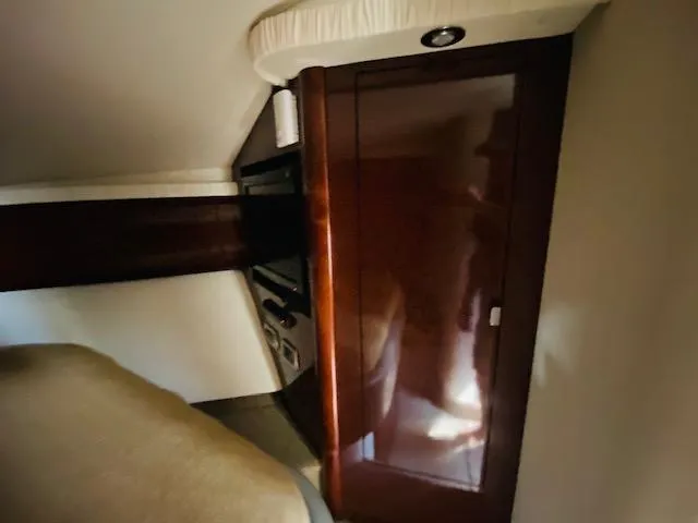 Slide: The Image of Interior cabin of 2008 Sea Ray 440 Sundancer with wood paneling and storage. - 32