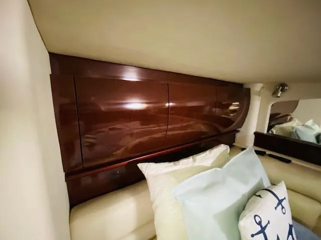 Slide: The Image of Interior cabin of 2008 Sea Ray 440 Sundancer with wooden cabinets and nautical-themed pillows. - 36