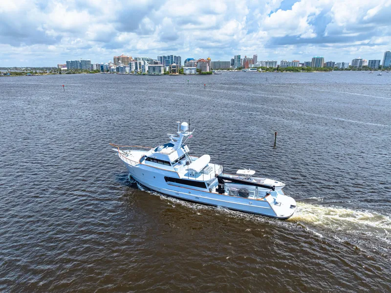 Slide: The Image of Expedition Freeport Yachts 1991 cruising on a river with city skyline in background. - 16