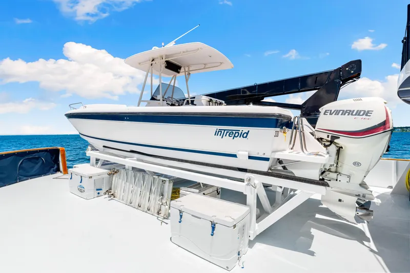 Slide: The Image of Intrepid boat on deck of 1991 Expedition Freeport Yacht, with Evinrude motor, ocean backdrop. - 20
