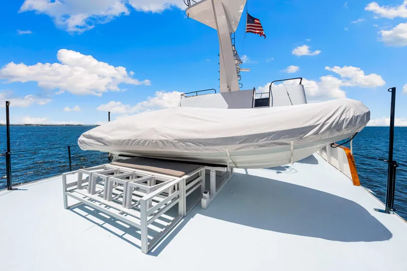 Slide: The Image of 1991 Expedition Freeport Yachts deck with covered equipment, ocean view, and blue sky. - 26