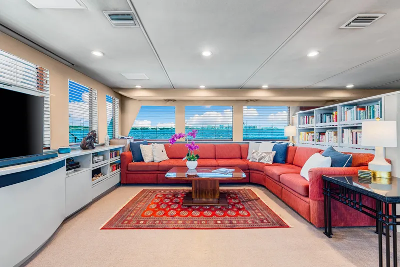 Slide: The Image of Luxurious 1991 Expedition Freeport Yachts interior with red sofa, bookshelves, and vibrant decor. - 37