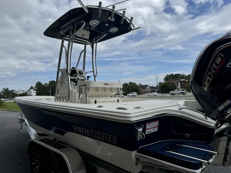 Slide: The Image of 2025 Pathfinder 2300 HPS boat with T-top and Yamaha engine, parked outdoors. - 11