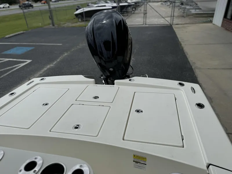 Slide: The Image of 2025 Pathfinder 2300 HPS boat with outboard motor, docked on pavement. - 14