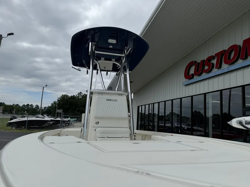 Slide: The Image of 2025 Pathfinder 2300 HPS boat at dealership, overcast sky, Custom sign in background. - 7