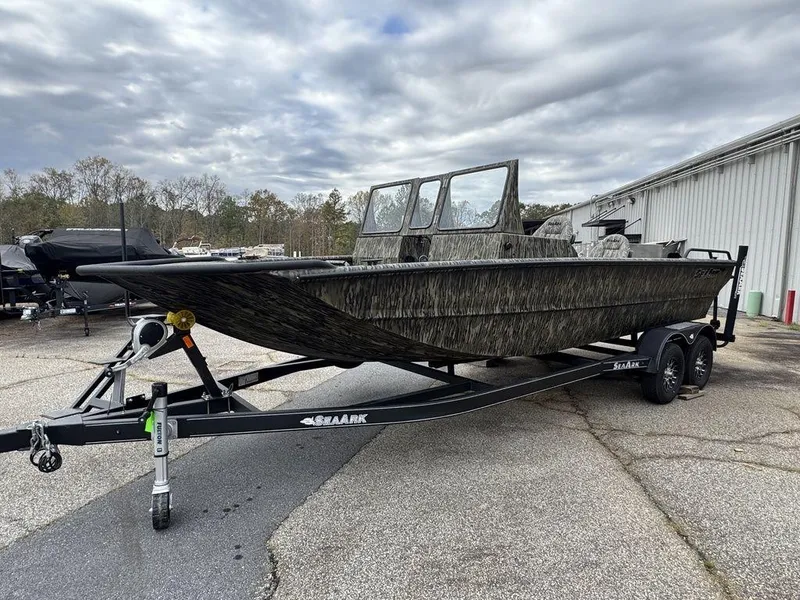 Slide: The Image of 2025 SeaArk Predator boat on trailer, parked outdoors under a partly cloudy sky. - 11