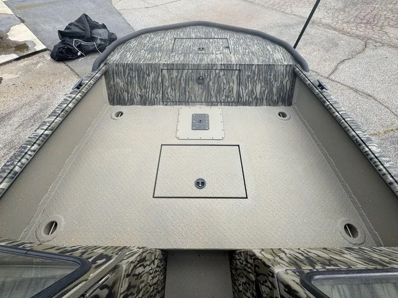 Slide: The Image of 2025 SeaArk Predator boat interior with captain's chair and dashboard, parked outdoors. - 16