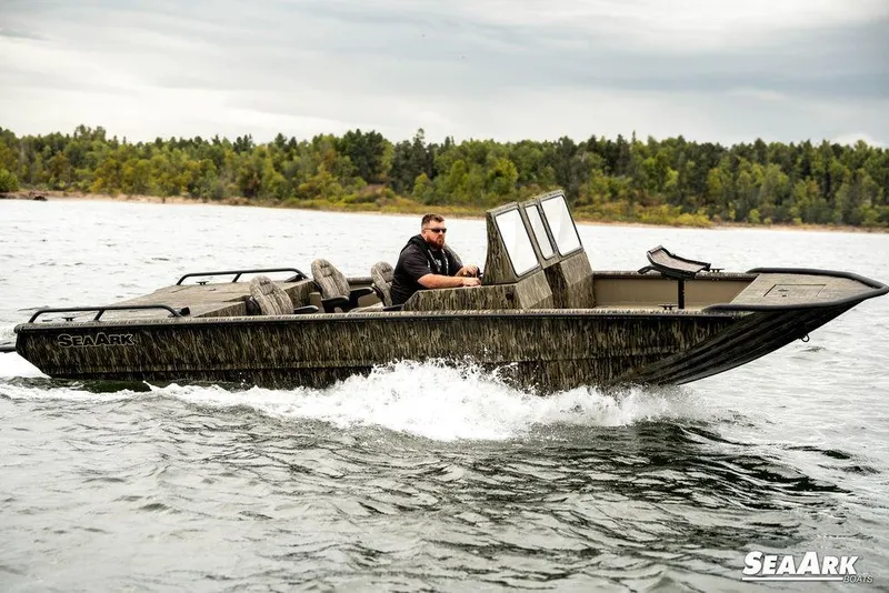 Slide: The Image of 2025 SeaArk Predator boat navigating on a lake under cloudy skies. - 27