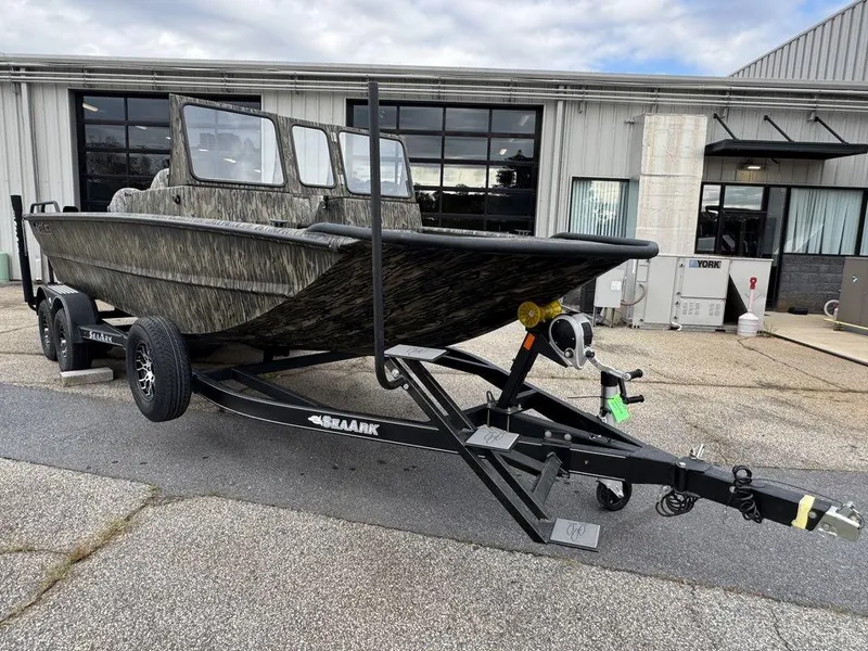 Slide: The Image of 2025 SeaArk Predator boat on trailer, parked outside a building. - 8