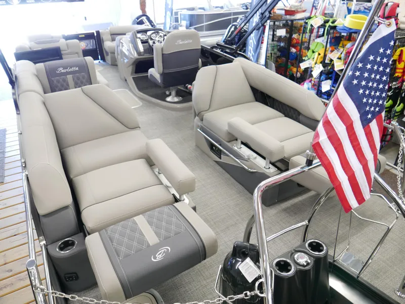 Slide: The Image of 2024 Barletta Lusso 23M pontoon boat interior with luxurious seating and American flag. - 45