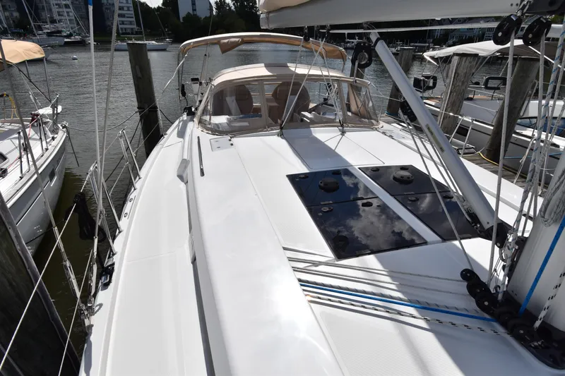 Slide: The Image of 2019 Hanse 458 sailboat docked at marina, showcasing sleek deck design. - 10