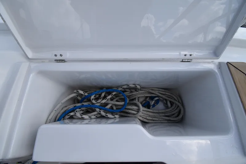 Slide: The Image of Open storage compartment on 2019 Hanse 458 yacht with coiled ropes inside. - 27
