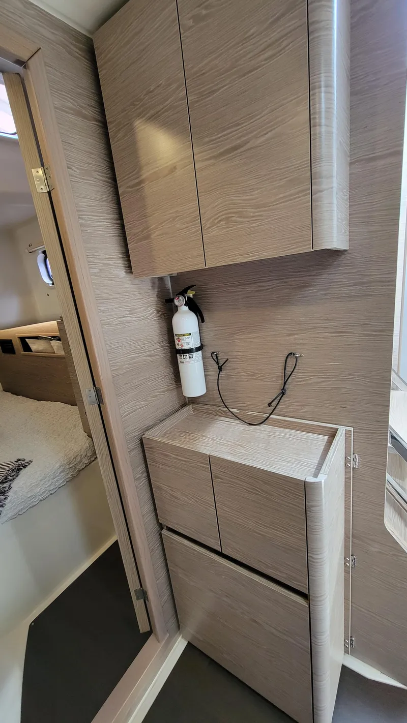 Slide: The Image of Interior of 2019 Hanse 458 yacht with modern wood cabinetry and fire extinguisher. - 39