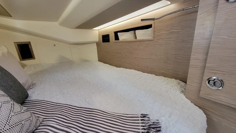 Slide: The Image of Cozy cabin interior of 2019 Hanse 458 yacht with modern bedding and storage. - 40