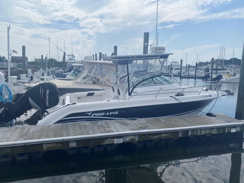 The Image of 2005 Pro-Line 24 Walkaround boat docked at marina. - 0