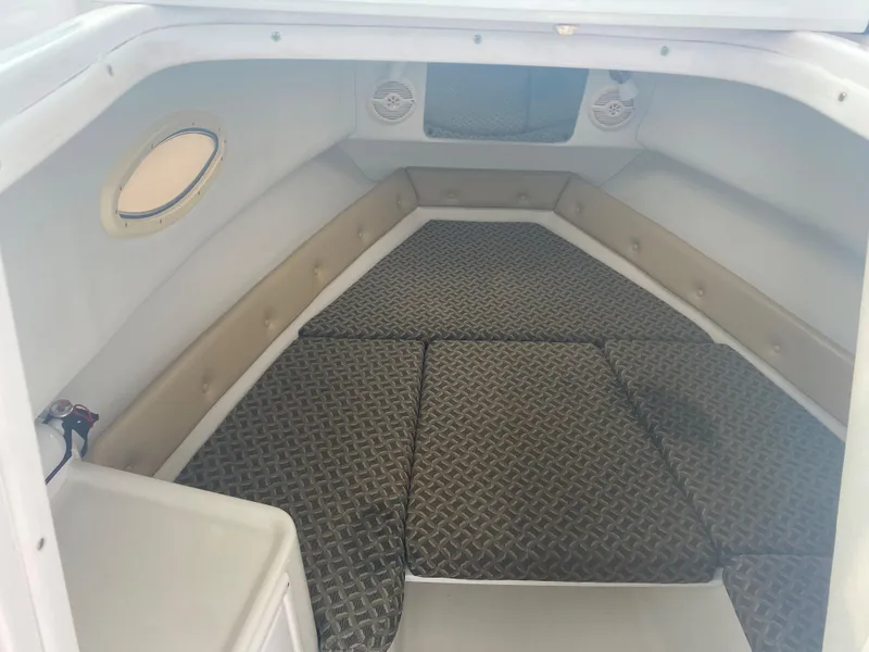 Slide: The Image of Interior of a 2005 Pro-Line 24 Walkaround boat with cushioned sleeping area. - 3