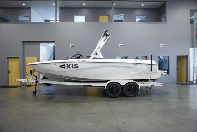 Slide: The Image of 2025 Axis A225 boat on trailer in showroom. - 1