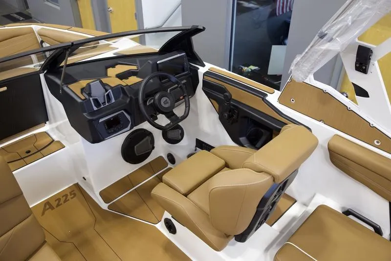 Slide: The Image of 2025 Axis A225 boat interior with tan seats and modern dashboard design. - 12