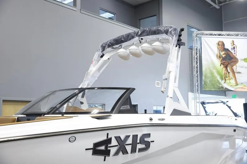 Slide: The Image of 2025 Axis A225 boat in showroom, featuring sleek design and modern wakeboard tower. - 7