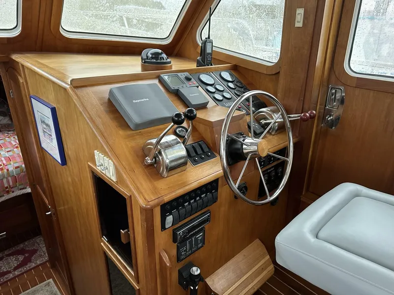 Slide: The Image of 2003 Sabre 36 Fly Bridge Sedan helm with wooden dashboard and steering wheel. - 20