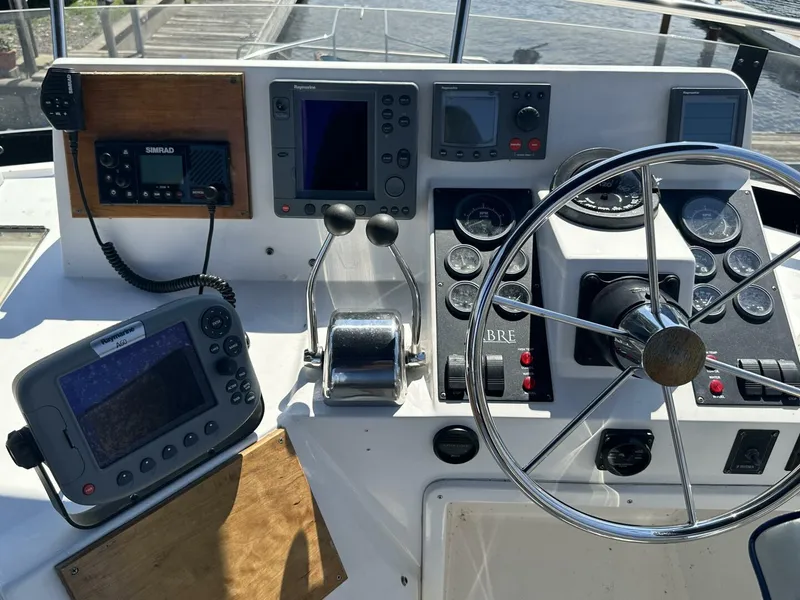 Slide: The Image of 2003 Sabre 36 Fly Bridge Sedan helm with navigation equipment and steering wheel. - 22