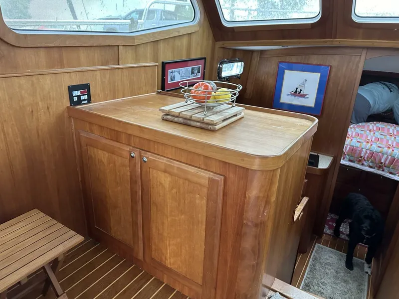 Slide: The Image of Interior of 2003 Sabre 36 Fly Bridge Sedan with wooden cabinetry and fruit basket. - 26