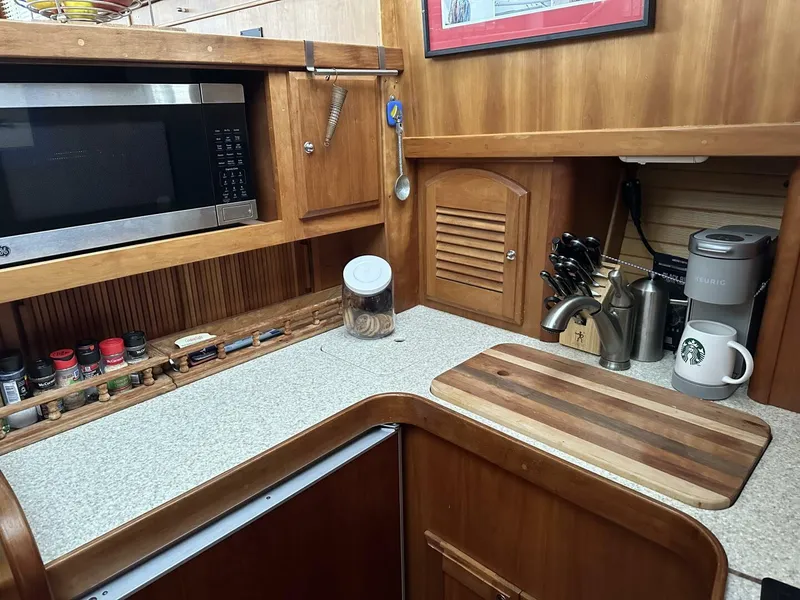 Slide: The Image of 2003 Sabre 36 Fly Bridge Sedan kitchen with microwave, cutting board, and coffee maker. - 29