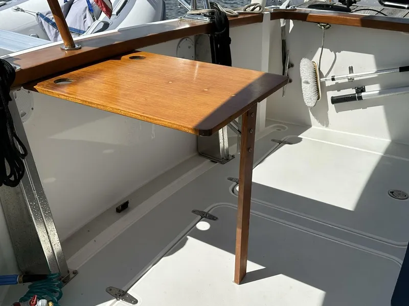 Slide: The Image of 2003 Sabre 36 Fly Bridge Sedan cockpit with wooden table and cleaning tools. - 36