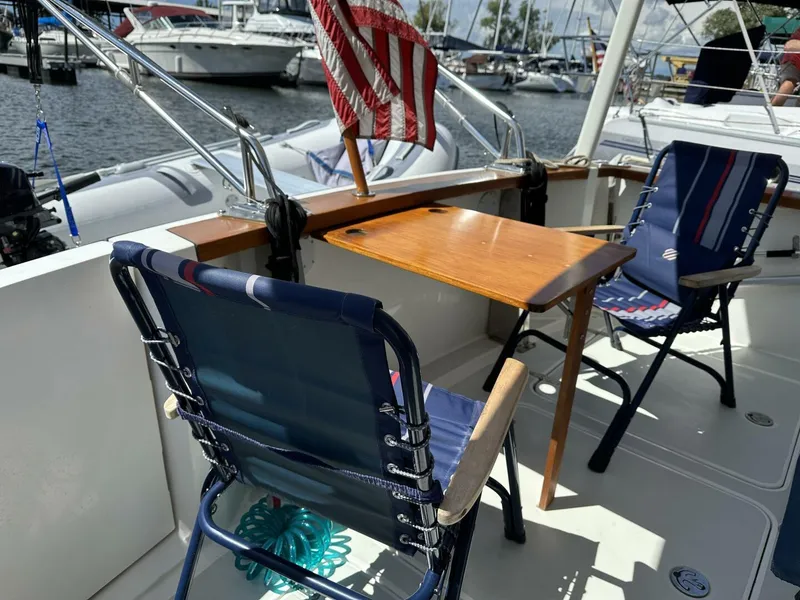Slide: The Image of 2003 Sabre 36 Fly Bridge Sedan with chairs and table on deck, docked at marina. - 37