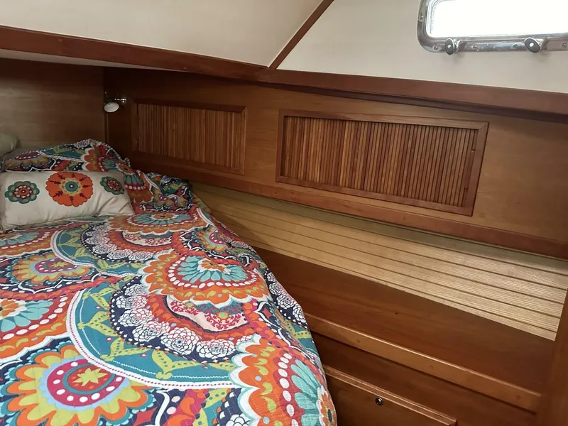Slide: The Image of Cozy cabin interior of 2003 Sabre 36 Fly Bridge Sedan with colorful bedding and wooden accents. - 41