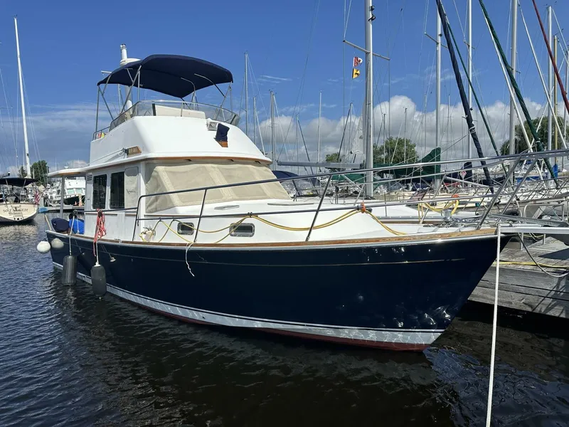 Slide: The Image of 2003 Sabre 36 Fly Bridge Sedan docked at marina under clear blue sky. - 5