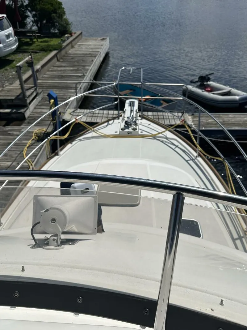 Slide: The Image of 2003 Sabre 36 Fly Bridge Sedan docked, view from bow, with water and dock in background. - 6