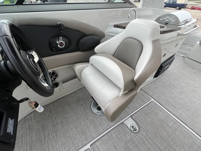 Slide: The Image of 2019 Crownline Eclipse E285 boat interior with steering wheel and captain's chair. - 23