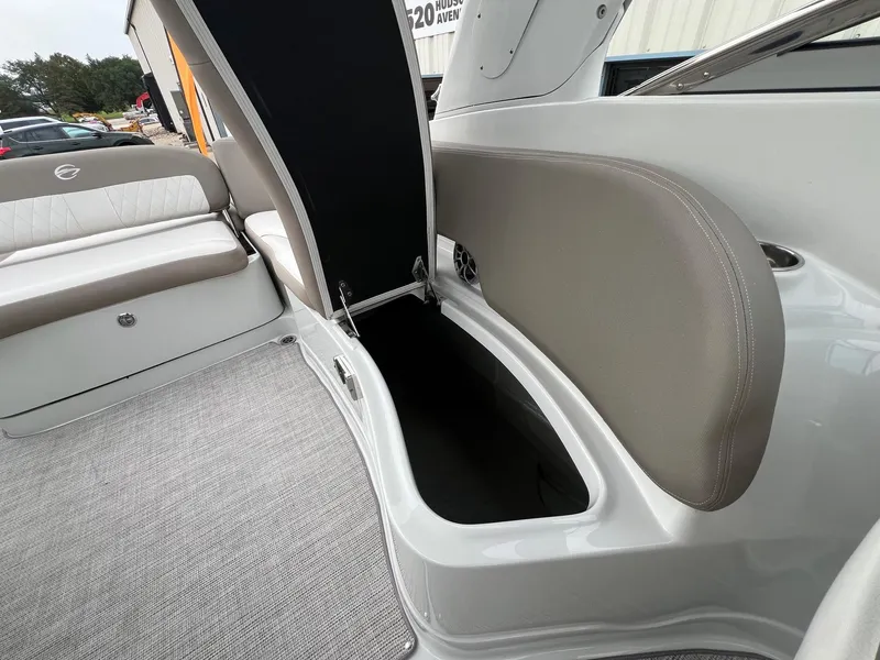 Slide: The Image of 2019 Crownline Eclipse E285 boat interior with open storage compartment and cushioned seating. - 28
