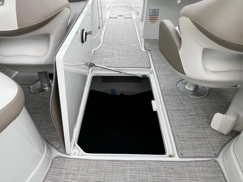 Slide: The Image of 2019 Crownline Eclipse E285 boat interior with open storage compartment and cushioned seats. - 30