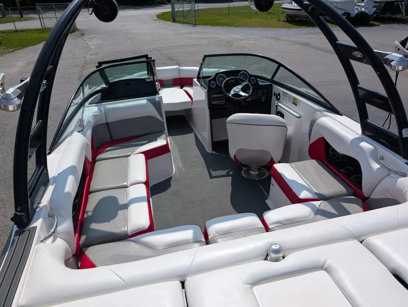 Slide: The Image of 2014 Moomba Mondo boat interior with white and red seating, steering wheel, and open layout. - 11
