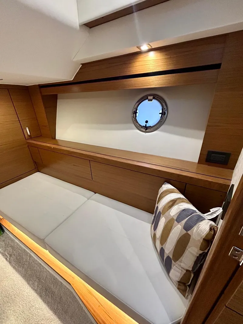 Slide: The Image of 2022 Tiara Yachts C39 Coupe interior with wooden finish and porthole window. - 10