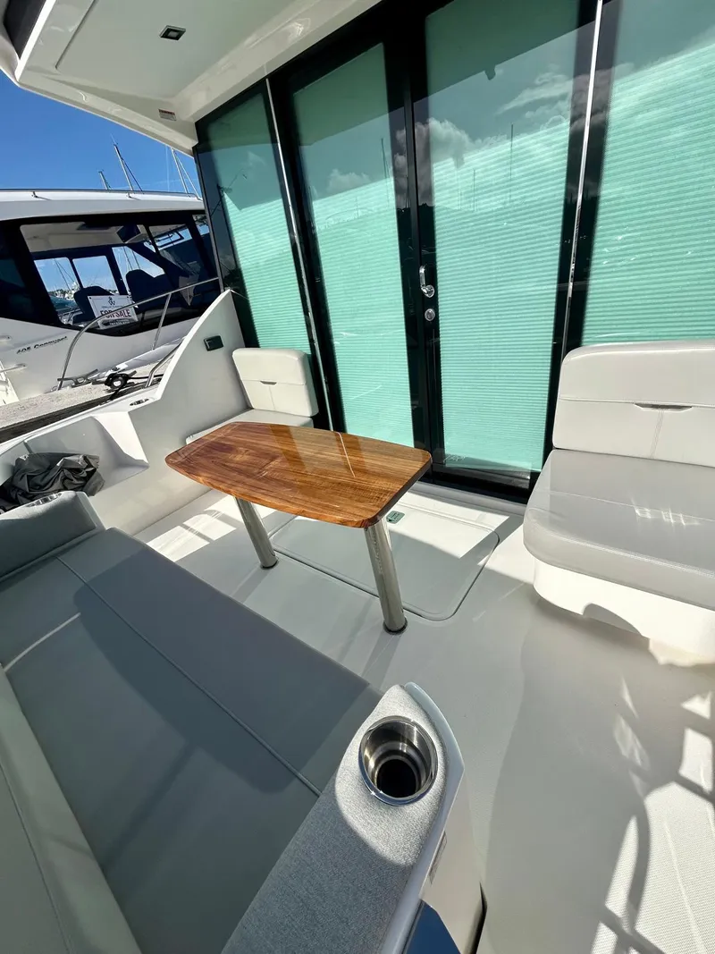 Slide: The Image of 2022 Tiara Yachts C39 Coupe interior with seating and wooden table. - 14