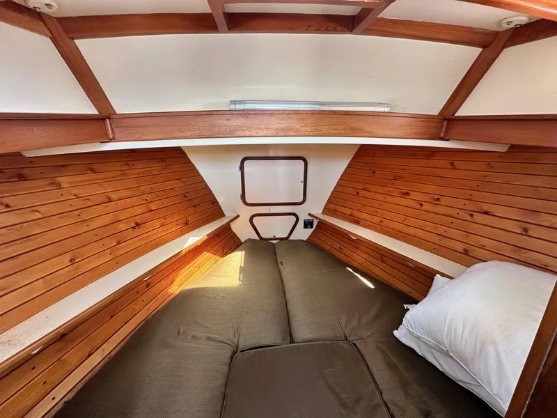 Slide: The Image of Cozy cabin interior of 1998 Mast & Mallet Rabbit 34 with wooden paneling and bedding. - 10