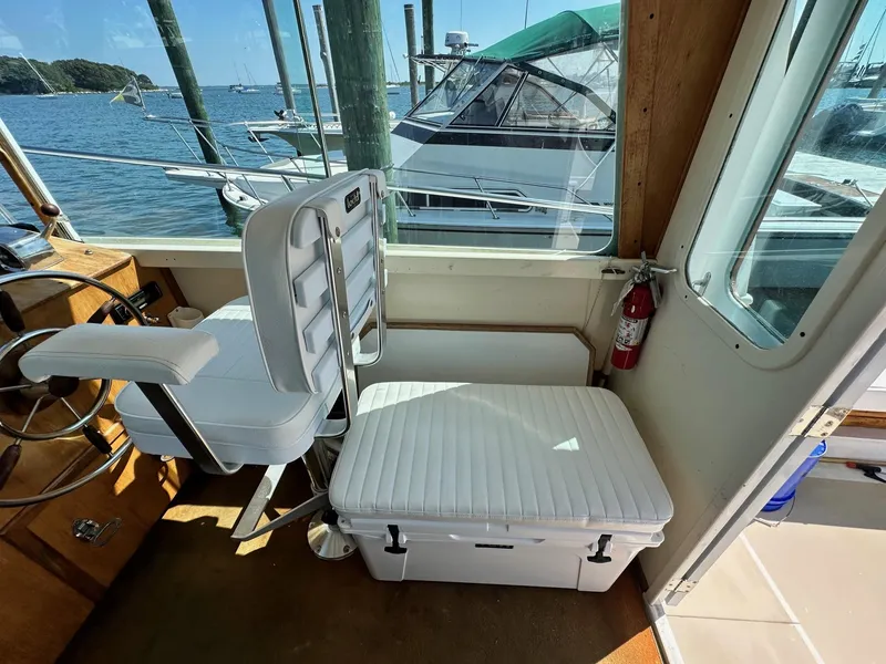 Slide: The Image of Interior of 1998 Mast & Mallet Rabbit 34 boat with white seating and steering wheel. - 16