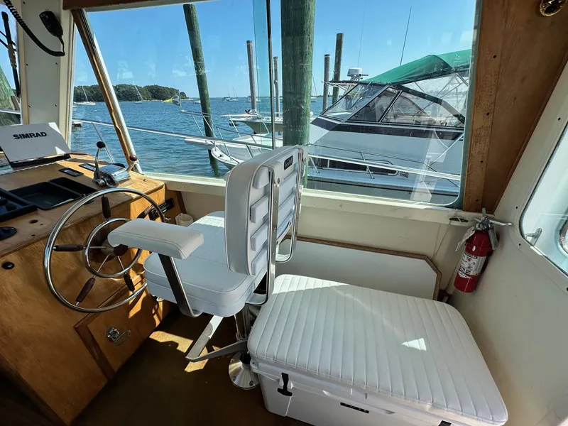 Slide: The Image of Interior of 1998 Mast & Mallet Rabbit 34 boat with steering wheel and seating. - 17