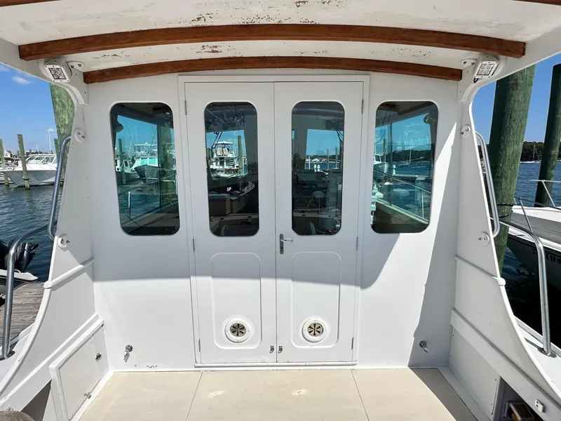 Slide: The Image of 1998 Mast & Mallet Rabbit 34 boat stern view with white doors and marina background. - 18
