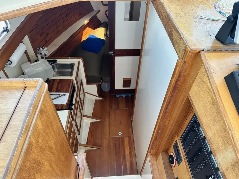 Slide: The Image of Interior of 1998 Mast & Mallet Rabbit 34 sailboat, featuring wooden cabinetry and compact kitchen area. - 20