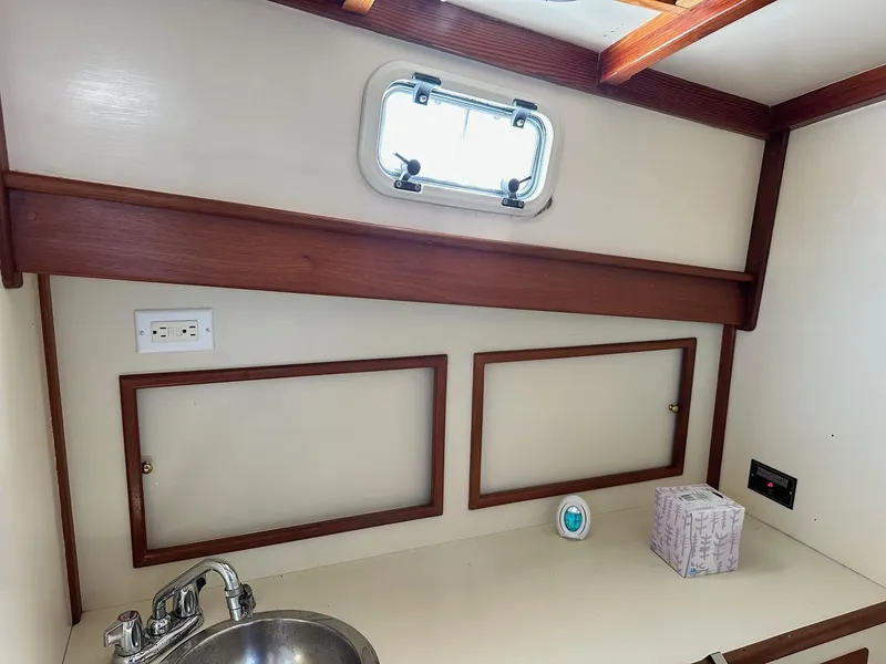 Slide: The Image of Interior of 1998 Mast & Mallet Rabbit 34 boat with sink and storage cabinets. - 22