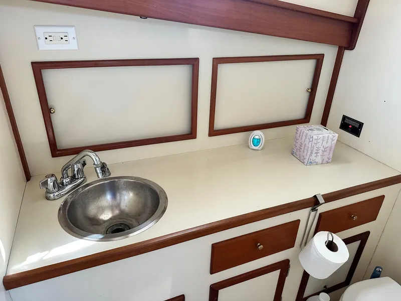 Slide: The Image of 1998 Mast & Mallet Rabbit 34 boat interior with sink and wooden cabinetry. - 23