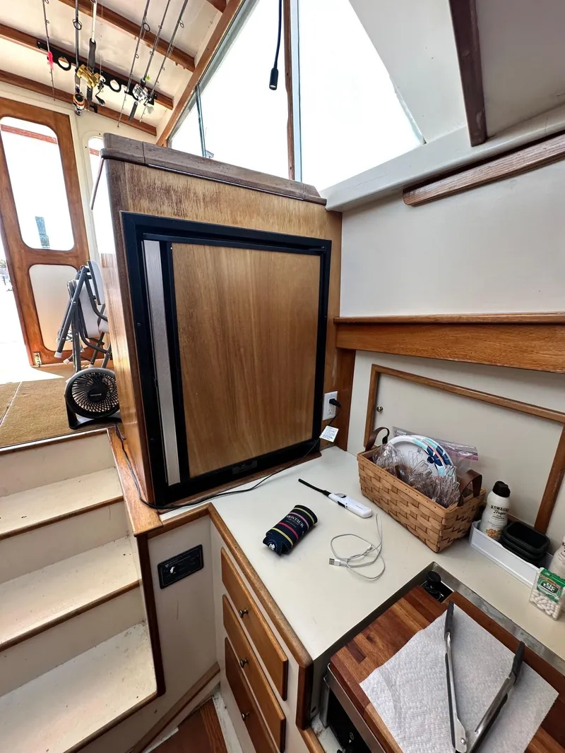 Slide: The Image of Interior of 1998 Mast & Mallet Rabbit 34 boat with wooden cabinetry and fishing rods. - 26