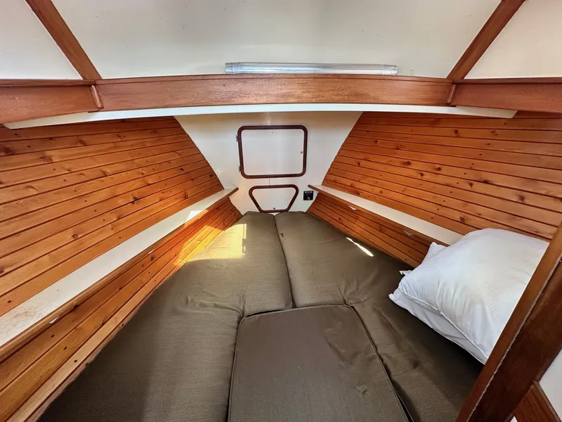 Slide: The Image of Cozy cabin interior of 1998 Mast & Mallet Rabbit 34 with wooden paneling and bedding. - 27