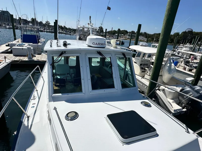 Slide: The Image of Mast & Mallet Rabbit 34 boat, 1998 model, docked in a marina with clear skies. - 7