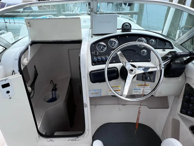 Slide: The Image of 2006 Hurricane SunDeck 260 OB boat interior with steering wheel and control panel. - 11